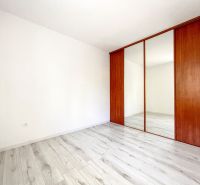 Ein Zimmer mit Holzboden und einem Einbauschrank in einer 2-Zimmer-Wohnung.
