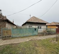 Ein Einfamilienhaus in Sikenica mit einem älteren Zaun und Garten, umgeben von weiteren Häusern.