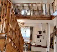 Innenraum eines Einfamilienhauses mit Treppe und Kamin, Boden mit Holzdekor.