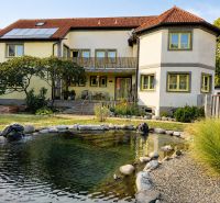 Einfamilienhaus in Podersdorf am See mit großem Garten, Teich und Solarpanelen.