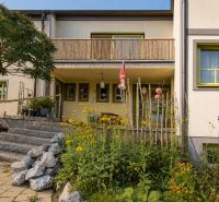 Ein Einfamilienhaus in Podersdorf am See mit Steintreppen und einem Garten voller Blumen.