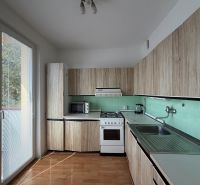 Küche in einer 3-Zimmer-Wohnung mit Holzboden und direktem Zugang zum Balkon.