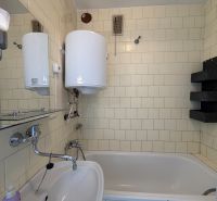 Badezimmer in einer 3-Zimmer-Wohnung mit Badewanne, Waschbecken und Wassererhitzer.