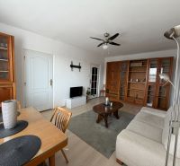 Wohnzimmer einer 3-Zimmer-Wohnung mit Holzmöbeln und einem Boden in Holzoptik.