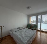 Schlafzimmer in einer 3-Zimmer-Wohnung mit Holzboden, Bett und Sesseln.
