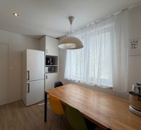 Eine Küche in hellen Farben mit einem Holzboden in einer 3-Zimmer-Wohnung.