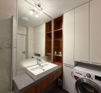Badezimmer mit Waschbecken, Waschmaschine und Stauraum in einer 3-Zimmer-Wohnung.