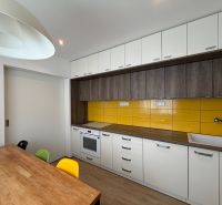 Küche in einer 3-Zimmer-Wohnung mit weißen Oberschränken und gelben Fliesen.