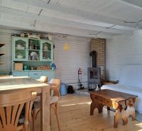Das Innere der Hütte mit einem Holzboden, Holzmöbeln und einem Ofen.