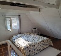 Schlafzimmer mit Holzboden und einem Bett in einer Hütte.