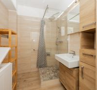 Badezimmer mit Duschkabine und Boden in Holzoptik in einer 3-Zimmer-Wohnung.