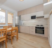 Eine Küche in einer 3-Zimmer-Wohnung mit Holzelementen und Essecke, hell und geräumig.