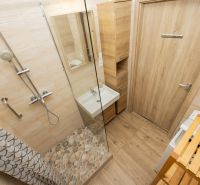 Badezimmer in einer 3-Zimmer-Wohnung mit Holzelementen und Duschkabine.
