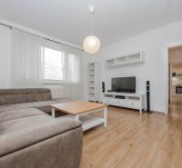 Wohnzimmer mit Ecksofa, Fernseher und Holzboden in einer 3-Zimmer-Wohnung.