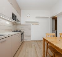 Küche in einer 3-Zimmer-Wohnung mit Holzboden und Holzmöbeln.