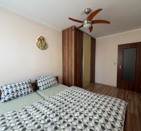 Schlafzimmer in einer 3-Zimmer-Wohnung mit Doppelbett, Einbauschrank und Boden mit Holzdekor.