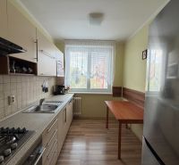 Küche in einer 3-Zimmer-Wohnung mit einem Holzboden und einer Küchenzeile.