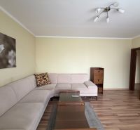 Wohnzimmer in einer 3-Zimmer-Wohnung mit Ecksofa und Holzboden.