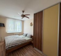 Schlafzimmer in einer 3-Zimmer-Wohnung mit Bett, Schrank und Holzboden.