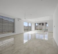 Geräumiger Wohnbereich im Einfamilienhaus mit großen Fenstern und glänzenden Fliesen.