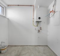 Weißer Raum mit Boiler und Holzboden in einem Einfamilienhaus.