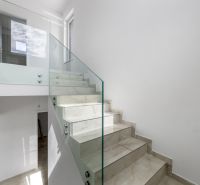 Glasgeländer mit Treppe im Einfamilienhaus, heller Raum, schlichtes Design.