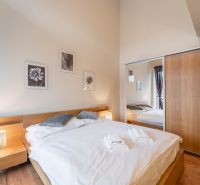 Schlafzimmer mit Bett und Holzboden in einem Ferienapartment.