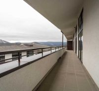Der Balkon des Ferienapartments in Donovaly bietet Blick auf die umliegenden Berge und die Dächer der Gebäude.