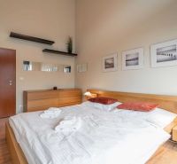 Helles Schlafzimmer in einer Ferienwohnung mit Holzboden und einfacher Einrichtung.