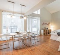 Ferienwohnung mit Esstisch, bequemen Sofas und einem Boden in Holzoptik.