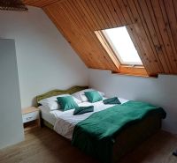 Ein Dachzimmer in einer Hütte mit einem Doppelbett und einem Dachfenster.