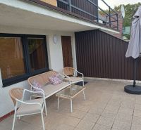 Terrasse der Hütte in Kaluža mit Sitzgelegenheiten und Sonnenschirm.