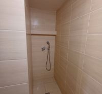 Badezimmer mit barrierefreier Dusche und hellen Keramikfliesen in der Hütte.