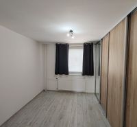 Zimmer in einer 3-Zimmer-Wohnung mit Holzboden und Einbauschrank.