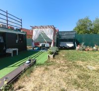 Der Garten des Einfamilienhauses in Divín mit Pavillon, Schaukel und grünem Rasen.
