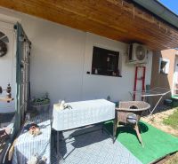 Die Terrasse des Einfamilienhauses in Divín mit Baldachin, Tisch und Rattansessel.