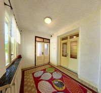 Der Flur in einem Einfamilienhaus mit einem bunten Teppich und Glastüren.
