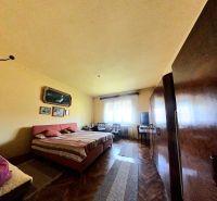 Schlafzimmer in einem Einfamilienhaus mit Holzboden, Bett, Schränken, Bilder an der Wand.