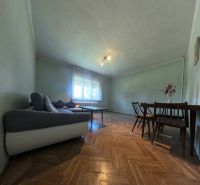 Wohnzimmer in einem Einfamilienhaus mit Sofa, Tisch und Holzboden.