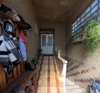 Eingangsbereich eines Einfamilienhauses mit Jacken und Topfpflanzen.