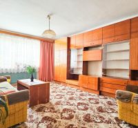 Wohnzimmer in einem Einfamilienhaus mit Sofa, Sessel und großer Schrankwand.