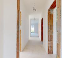 Ein Flur im Einfamilienhaus, bereit zur Fertigstellung, mit Blick in den Garten.