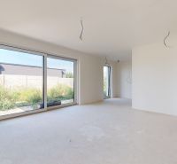 Ein geräumiges Wohnzimmer in einem Einfamilienhaus mit großen Fenstern und Blick in den Garten.