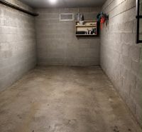 Leere Garage mit einem Werkzeugregal und Beleuchtung, Betonboden.