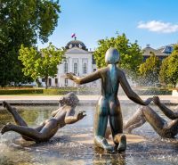Ein Brunnen mit Bronzeskulpturen und die Präsidentin in den Gärten in Bratislava – Altstadt auf der Banskobystrická.