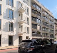 Banskobystrická Straße, Bratislava - Staré Mesto, zeigt moderne Fassaden von Gebäuden und geparkte Autos.