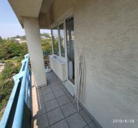 Balkon einer 2-Zimmer-Wohnung mit blauem Geländer und Blick ins Grüne in Bratislava.