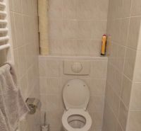 Badezimmer mit Toilette, Papierhalter und Handtuchhalter in einer 2-Zimmer-Wohnung.