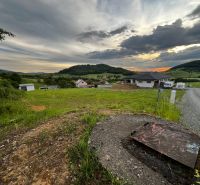 Grundstücke - Wohnen in Stožok mit einer Kulisse aus Grünflächen und Landhäusern bei Sonnenuntergang.