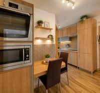 Küche in einer 3-Zimmer-Wohnung mit Holzboden-Dekor und eingebauten Geräten.